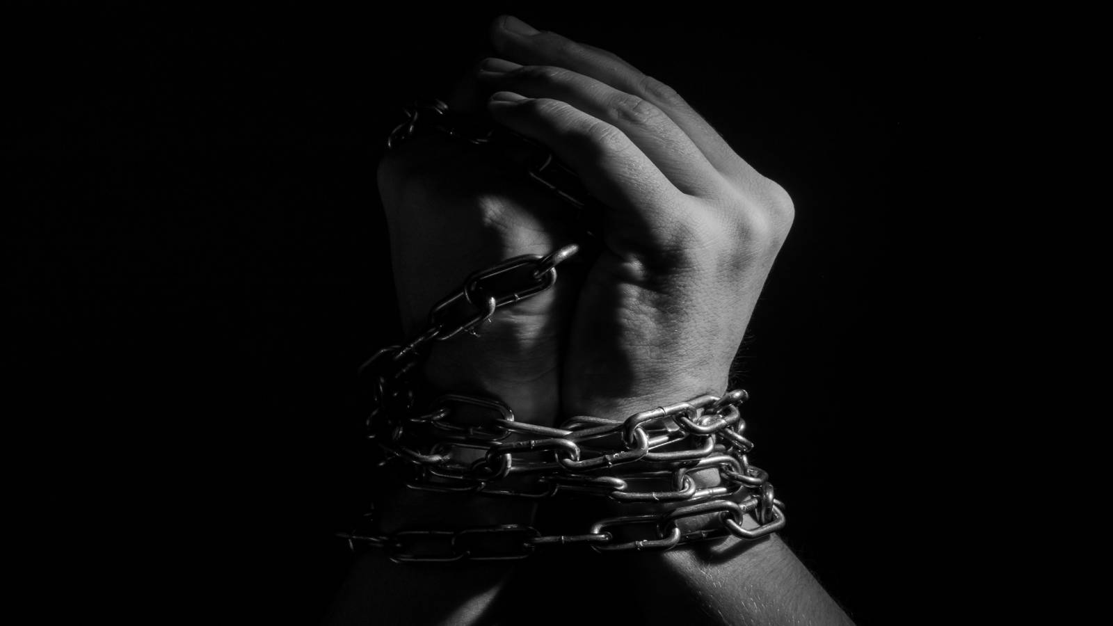 A man with his hands wrapped in chains