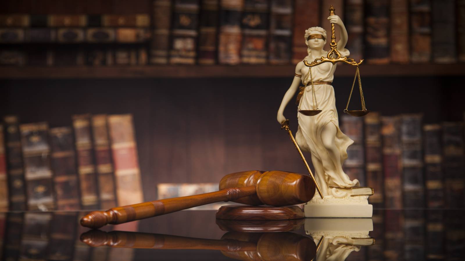 Lady Justice beside a gavel on a desk