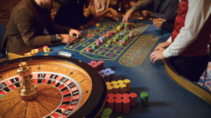 Hand of a croupier on a roulette wheel in a casino.