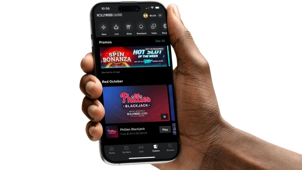 Hollywood Casino Michigan homepage on a mockup of an Android smartphone, held by a mans hand.
